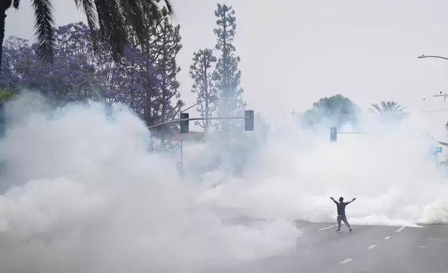 Tear gas fills the street as protesters confront Border Patrol personnel during a demonstration over the dozens detained in an operation by federal immigration authorities a day earlier in the Paramount section of Los Angeles, on Saturday, June 7, 2025. (AP Photo/Eric Thayer)