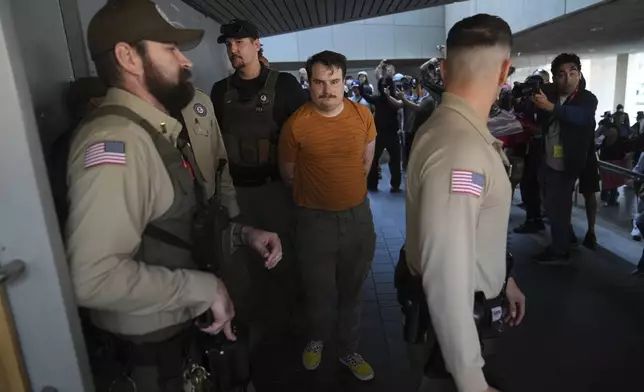Law enforcement detain a protester at the U.S. Department of Justice Federal Bureau of Prisons after federal immigration authorities conducted an operation on Friday, June 6, 2025, in Los Angeles. (AP Photo/Jae C. Hong)