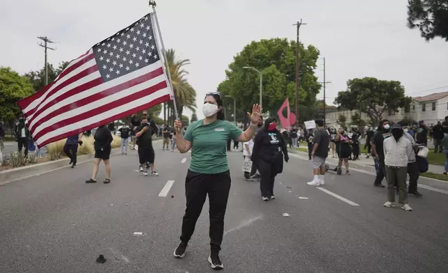 Protesters confront Border Patrol personnel during a demonstration over the dozens detained in an operation by federal immigration authorities a day earlier in Paramount section of Los Angeles Saturday, June 7, 2025. (AP Photo/Eric Thayer)