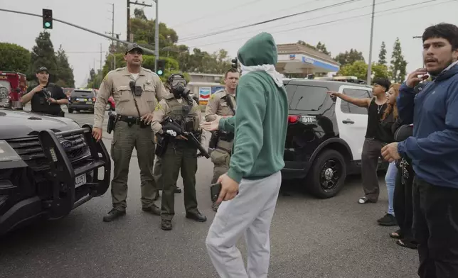 Protesters confront Border Patrol personnel during a demonstration over the dozens detained in an operation by federal immigration authorities a day earlier in Paramount section of Los Angeles Saturday, June 7, 2025. (AP Photo/Eric Thayer)