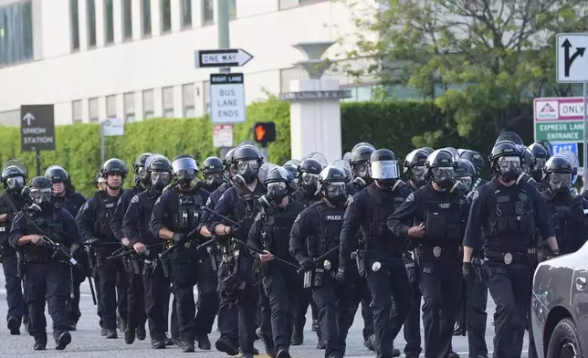 Los Angeles Police officers gather during a protest after federal immigration authorities conducted an operation on Friday, June 6, 2025, in Los Angeles. (AP Photo/Damian Dovarganes)