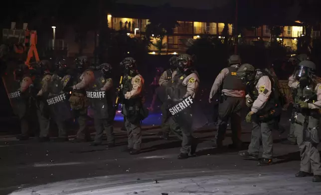 Los Angeles County Sheriffs stand during a protest in Compton, Calif., Saturday, June 7, 2025, after federal immigration authorities conducted operations. (AP Photo/Ethan Swope)