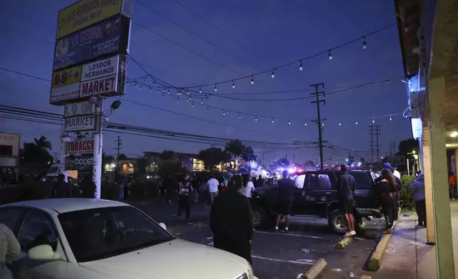 Spectators watch during a protest in Compton, Calif., Saturday, June 7, 2025, after federal immigration authorities conducted operations. (AP Photo/Ethan Swope)