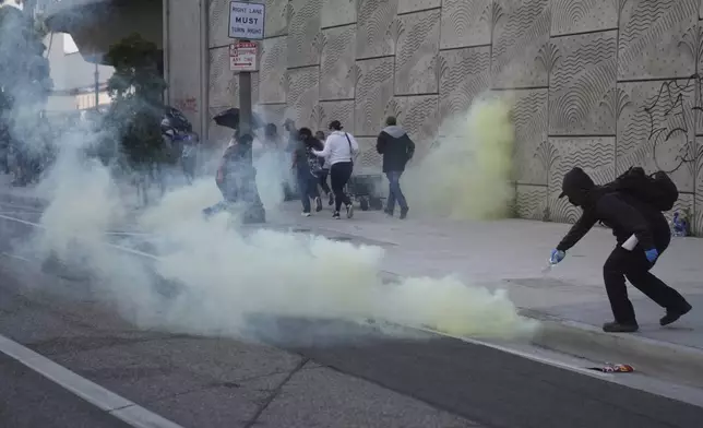 A protester pours water over a tear gas canister during a protest after federal immigration authorities conducted an operation on Friday, June 6, 2025, in Los Angeles. (AP Photo/Jae C. Hong)