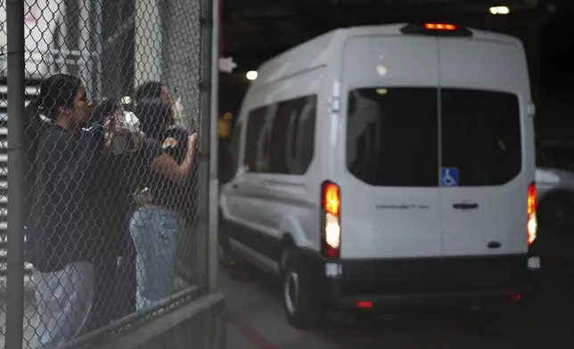Protesters watch as federal immigration authorities arrive with detainees at the Federal Building after conducting operations in Los Angeles, Saturday, June 7, 2025. (AP Photo/Eric Thayer)