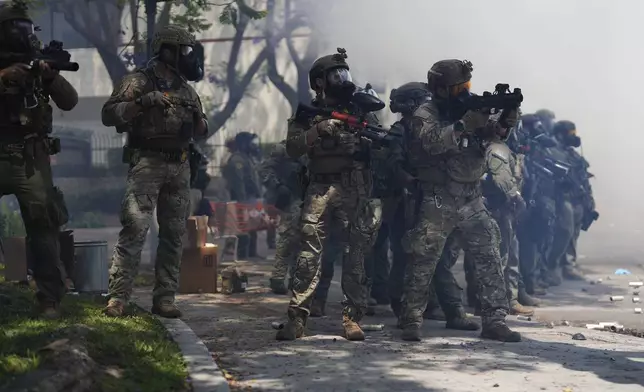 Law enforcement stand during a protest in the Paramount section of Los Angeles, Saturday, June 7, 2025, after federal immigration authorities conducted operations. (AP Photo/Eric Thayer)