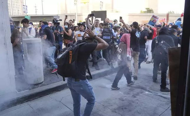 People react as a Department of Homeland Security officer shoots pepper balls during a protest at the U.S. Department of Justice Federal Bureau of Prisons after federal immigration authorities conducted an operation on Friday, June 6, 2025, in Los Angeles. (AP Photo/Jae C. Hong)