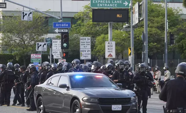 Los Angeles Police officers gather during a protest after federal immigration authorities conducted an operation on Friday, June 6, 2025, in Los Angeles. (AP Photo/Damian Dovarganes)