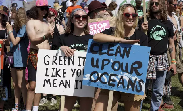 FILE - Protestors march to raise awareness of climate change and ecology on the second day of the Glastonbury Festival at Worthy Farm, Somerset, England, June 27, 2019. (Photo by Grant Pollard/Invision/AP, file)