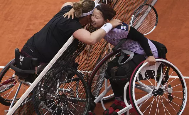Japan's Manami Tanaka, right, and winner Netherlands' Aniek Van Koot hug after their women's wheelchair singles quarterfinal match of the French Tennis Open at the Roland-Garros stadium in Paris, Thursday, June 5, 2025. (AP Photo/Lindsey Wasson)