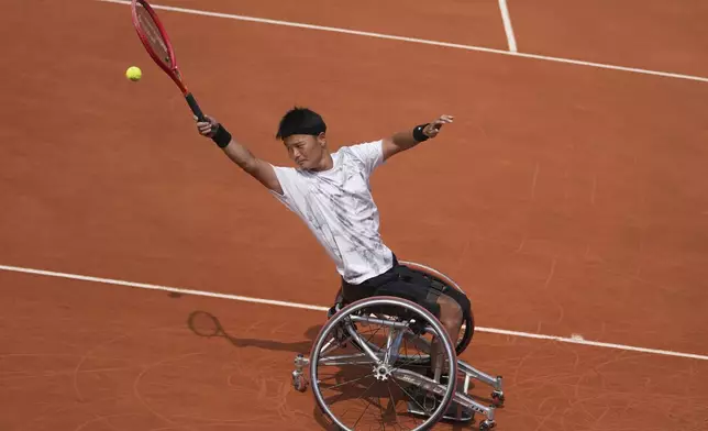 Japan's Takuya Miki plays a shot against Spain's Martin De La Puente during their men's wheelchair singles first round match of the French Tennis Open at the Roland-Garros stadium in Paris, Tuesday, June 3, 2025. (AP Photo/Thibault Camus)