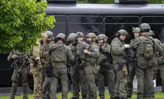 Law enforcement officers including local police, sheriffs and the FBI, stage less than a mile from a shooting in Brooklyn Park, Minn. on Saturday, June 14, 2025. (Alex Kormann/Star Tribune via AP)