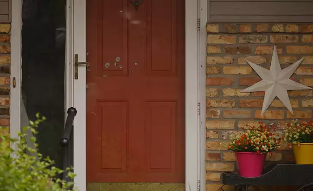 Bullet holes mark the front door of the house of Minnesota state Sen. John Hoffman and his wife who were shot earlier in the day, Saturday, June 14, 2025, in Champlin, Minn. (AP Photo/Bruce Kluckhohn)