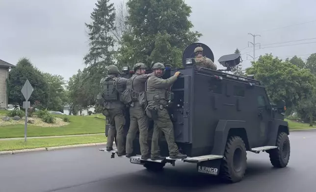 Police deploy as a manhunt is underway for a shooter that targeted two state lawmakers, in Brooklyn Park, Minn. on Saturday, June 14, 2025. (AP Photo/Tim Sullivan)