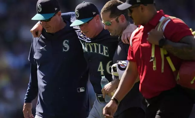 Seattle Mariners pitcher Trent Thornton (46) is helped off the field after suffering from heat exhaustion during the eighth inning of a baseball game against the Chicago Cubs, Saturday, June 21, 2025, in Chicago. (AP Photo/Erin Hooley)