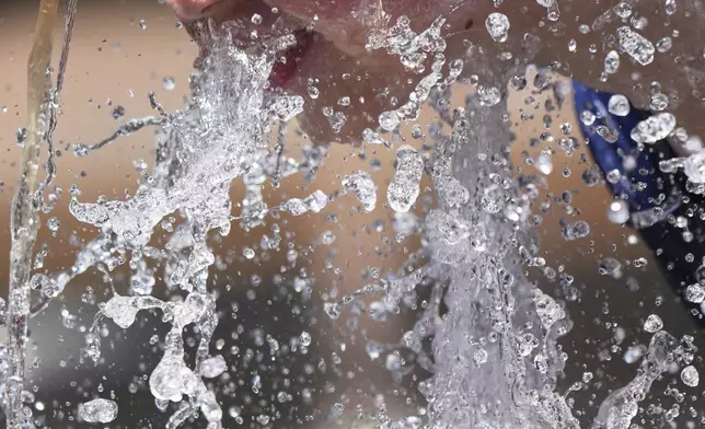 Jude Puroway cools off at a fountain during hot weather in Chicago, Sunday, June 22, 2025. (AP Photo/Nam Y. Huh)