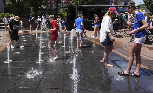 People cool off at a fountain during hot weather in Chicago, Sunday, June 22, 2025. (AP Photo/Nam Y. Huh)