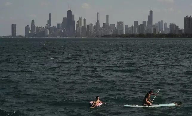 People cool off in a Lake Michigan shore Sunday, June 22, 2025, in Chicago. (AP Photo/Kiichiro Sato)