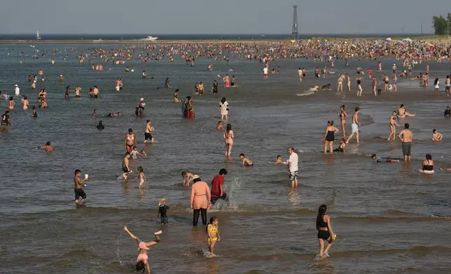 Beach goers crowd a public beach on the Lake Michigan shore, Sunday, June 22, 2025, in Chicago. (AP Photo/Kiichiro Sato)