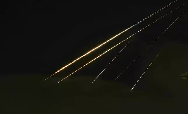 Traces of projectile illuminates the sky seen from northern Israel, Saturday, June 14, 2025. (AP Photo/Ariel Schalit)