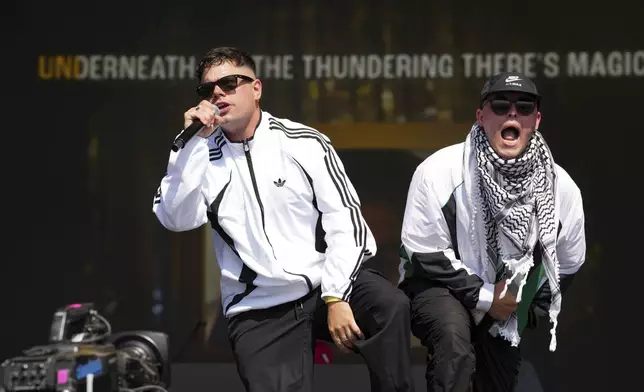 Naoise O Caireallain, left, and Liam Og of the hip hop trio Kneecap perform during the Glastonbury Festival in Worthy Farm, Somerset, England, Saturday, June 28, 2025. (Scott A Garfitt/Invision/AP)