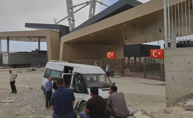 People wait after crossing from Iran into Turkey at Gurbulak Bazargan border post, in Gurbulak, Turkey, Monday, June 16, 2025. (AP Photo/Kadir Cesur)