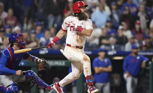 Philadelphia Phillies' Brandon Marsh, right, watches after hitting a game-winning RBI-single against Chicago Cubs pitcher Daniel Palencia during the 11th inning of a baseball game Monday, June 9, 2025, in Philadelphia. (AP Photo/Matt Slocum)