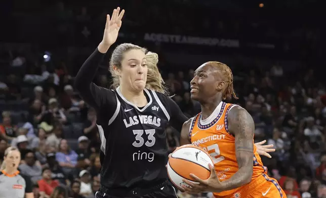 Connecticut Sun guard Saniya Rivers (22) drives to the basket against Las Vegas Aces center Elizabeth Kitley (33) during the first half of a WNBA basketball game Wednesday, June 25, 2025, in Las Vegas. (Steve Marcus/Las Vegas Sun via AP)