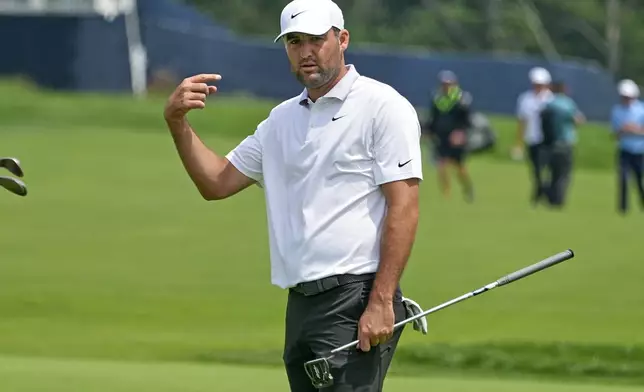 Scottie Scheffler gestures after putting on the 14th green during a practice round for the 2025 US Open golf championship at Oakmont Country Club in Oakmont, Pa., Monday, June 9, 2025. (AP Photo/Gene J. Puskar)