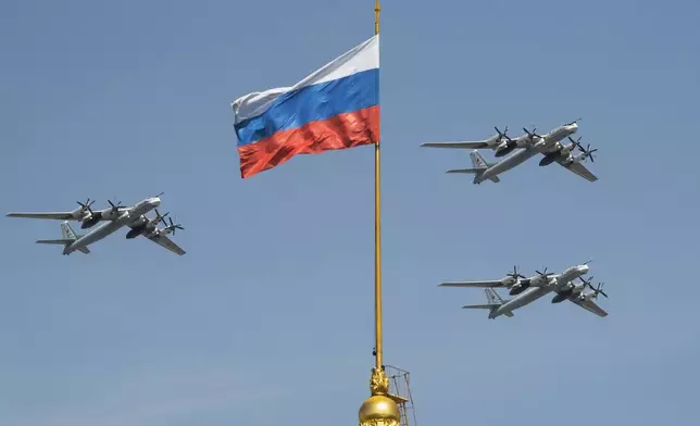 FILE - Russian Tu-95 strategic bombers fly past a Russian flag at the Kremlin complex during a rehearsal for the Victory Day military parade in Moscow, Russia, May 4, 2018. (AP Photo/Pavel Golovkin, File)