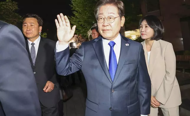 South Korea's Democratic Party's presidential candidate Lee Jae-myung, center, and his wife Kim Hea Kyung, right, greet supporters and residents as they leave from a home in Incheon, South Korea, Tuesday, June 3, 2025. (Choi Jae-gu/Yonhap via AP)