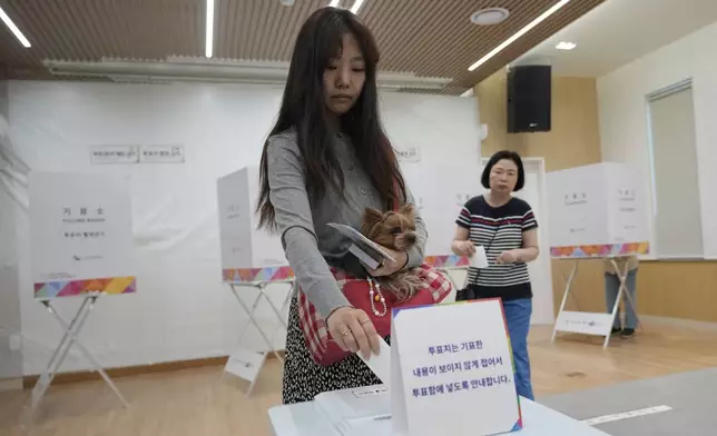A woman casts her vote for the presidential election at a polling station in Seoul, South Korea, Tuesday, June 3, 2025. (AP Photo/Ahn Young-joon)
