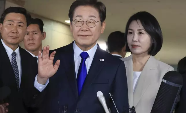 South Korea's Democratic Party's presidential candidate Lee Jae-myung, center, and his wife Kim Hea Kyung, right, greet supporters and residents as they leave from a home in Incheon, South Korea, Tuesday, June 3, 2025. (Choi Jae-gu/Yonhap via AP)