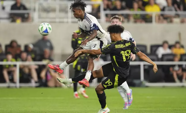 Columbus Crew forward Jacen Russell-Rowe (19) shoots against Vancouver Whitecaps defender Édier Ocampo, left, during the second half of an MLS soccer match Saturday, June 14, 2025, in Columbus, Ohio. (AP Photo/Jeff Dean)