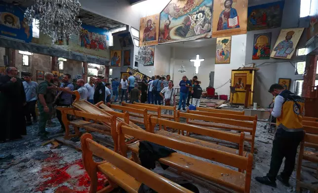 Syrians gather inside Mar Elias church where a suicide bomber detonated himself in Dweil'a in the outskirts of Damascus, Syria, Sunday June 22, 2025. (AP Photo/Omar Sanadiki)