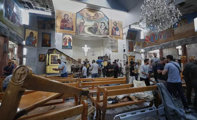 Syrian citizens and security forces inspect the damage inside Mar Elias church where a suicide bomber detonated himself in Dweil'a in the outskirts of Damascus, Syria, Sunday June 22, 2025. (AP Photo/Omar Sanadiki)