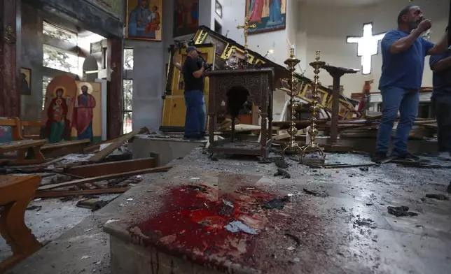 Syrian gather inside Mar Elias church where a suicide bomber detonated himself in Dweil'a in the outskirts of Damascus, Syria, June 22, 2025. (AP Photo/Omar Sanadiki)