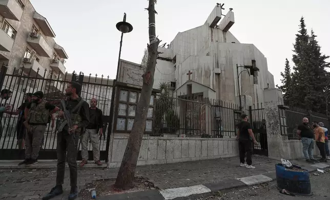 Syrian security forces stand guard outside Mar Elias church where a suicide bomber detonated himself in Dweil'a in the outskirts of Damascus, Syria, Sunday June 22, 2025. (AP Photo/Omar Sanadiki)