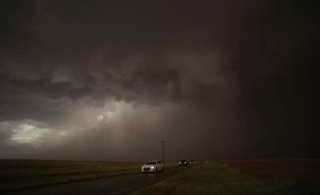 Cars dive away from a storm during a Project ICECHIP operation Thursday, June 5, 2025, in Morton, Texas. (AP Photo/Carolyn Kaster)