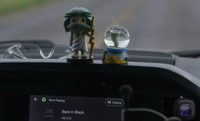 Dashboard mascots Zeus, left, and Tor, right, sit in a car as AC/DC's “Back in Black” plays on the stereo in Northern Illinois University's Husky Hail Hunter vehicle, as they drive into a storm during a Project ICECHIP operation, Friday, June 6, 2025, near Levelland, Texas. (AP Photo/Carolyn Kaster)