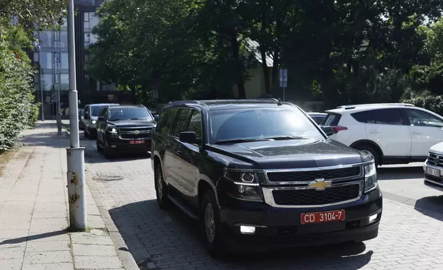 Cars carrying released Belarusian dissidents arrive at the US Embassy in Vilnius, Lithuania, Saturday, June 21, 2025 (AP Photo/Mindaugas Kulbis)