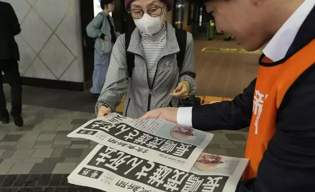 A person receives an extra edition of the Yomiuri Shimbun newspaper reporting that Shigeo Nagashima passed away Tuesday, June 3, 2025, in Tokyo. Nagashima, who was known in Japan as “Mr. Pro Baseball” in Japan and was one of the most famous people in the country during his playing days, has died. He was 89. (AP Photo/Shuji Kajiyama)