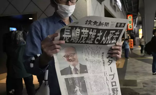 A person reads an extra edition of the Yomiuri Shimbun newspaper reporting that Shigeo Nagashima passed away Tuesday, June 3, 2025, in Tokyo. Nagashima, who was known in Japan as “Mr. Pro Baseball” in Japan and was one of the most famous people in the country during his playing days, has died. He was 89. (AP Photo/Shuji Kajiyama)
