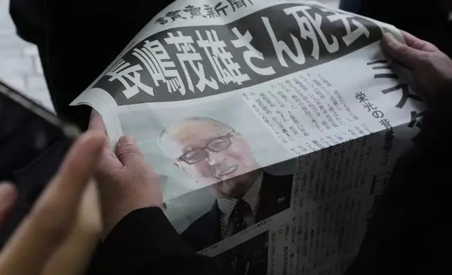 A person reads an extra edition of the Yomiuri Shimbun newspaper reporting that Shigeo Nagashima passed away Tuesday, June 3, 2025, in Tokyo. Nagashima, who was known in Japan as “Mr. Pro Baseball” in Japan and was one of the most famous people in the country during his playing days, has died. He was 89. (AP Photo/Shuji Kajiyama)