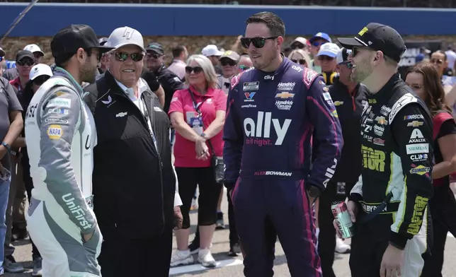 Chase Elliott, from left, team owner Rick Hendrick, Alex Bowman, and William Byron talk before a NASCAR Cup Series auto race at Michigan International Speedway in Brooklyn, Mich., Sunday, June 8, 2025. (AP Photo/Paul Sancya)