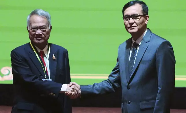 FILE - Cambodian Minister in charge of State Secretariat of Border Affairs Lam Chea, right, shakes hands with Thai Border Affairs Advisor to the Ministry of Foreign Affairs Prasas Prasasvinitchai, left, during a meeting of the Cambodian-Thai joint commission on demarcation for land boundary in Phnom Penh, Cambodia, Saturday, June 14, 2025. (AP Photo/Heng Sinith, file)