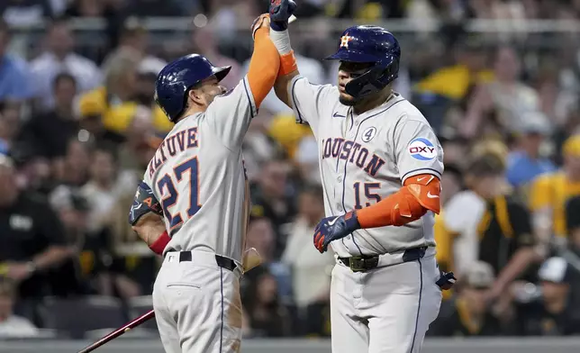 Houston Astros' Isaac Paredes, right, is greeted by Jose Altuve, left, after hitting a two-run home run during the ninth inning of a baseball game against the Pittsburgh Pirates, Tuesday, June 3, 2025, in Pittsburgh. (AP Photo/Matt Freed)