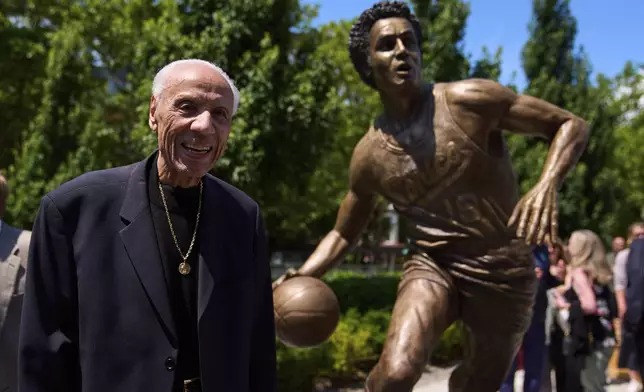 Former NBA basketball player and coach Lenny Wilkens poses for a photo with his statue after its unveiling outside of Climate Pledge Arena, Saturday, June 28, 2025, in Seattle. (AP Photo/Lindsey Wasson)