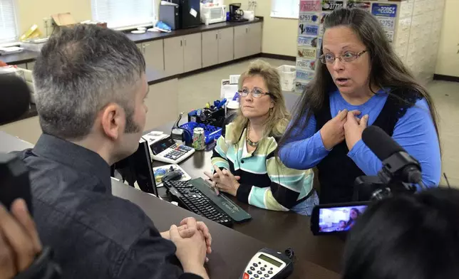 FILE - Rowan County Clerk Kim Davis, right, talks with David Moore following her office's refusal to issue marriage licenses at the Rowan County Courthouse in Morehead, Ky., on Sept. 1 2015. (AP Photo/Timothy D. Easley, File)