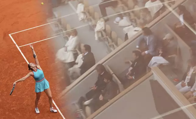 Fans are reflected in glass as Aryna Sabalenka of Belarus serves against Coco Gauff of the U.S. during the final match of the French Tennis Open at the Roland-Garros stadium in Paris, Saturday, June 7, 2025. (AP Photo/Lindsey Wasson)